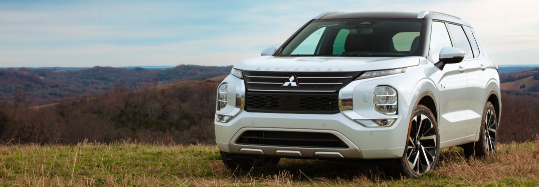 White 2023 Mitsubishi Outlander Plug-In Hybrid Parked in Field